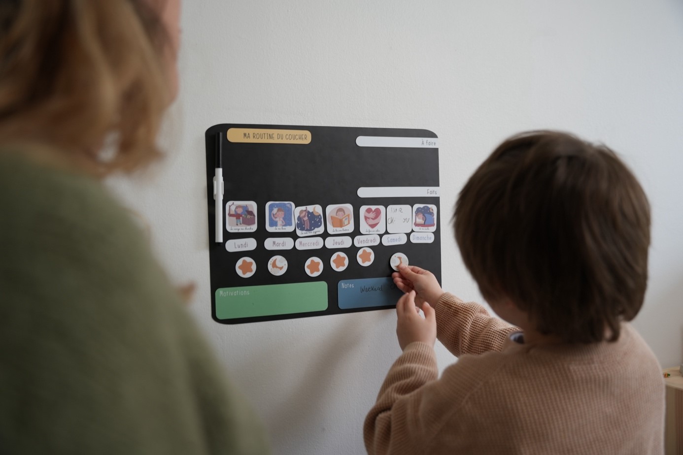 Enfant utilisant un tableau de routine magnétique
