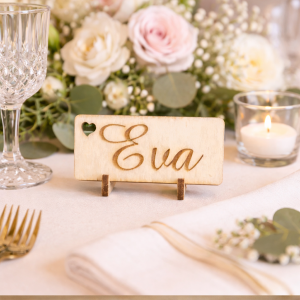 Étiquettes en bois personnalisées mariage gravées avec le prénom Eva, sur table décorative avec fleurs et bougie.