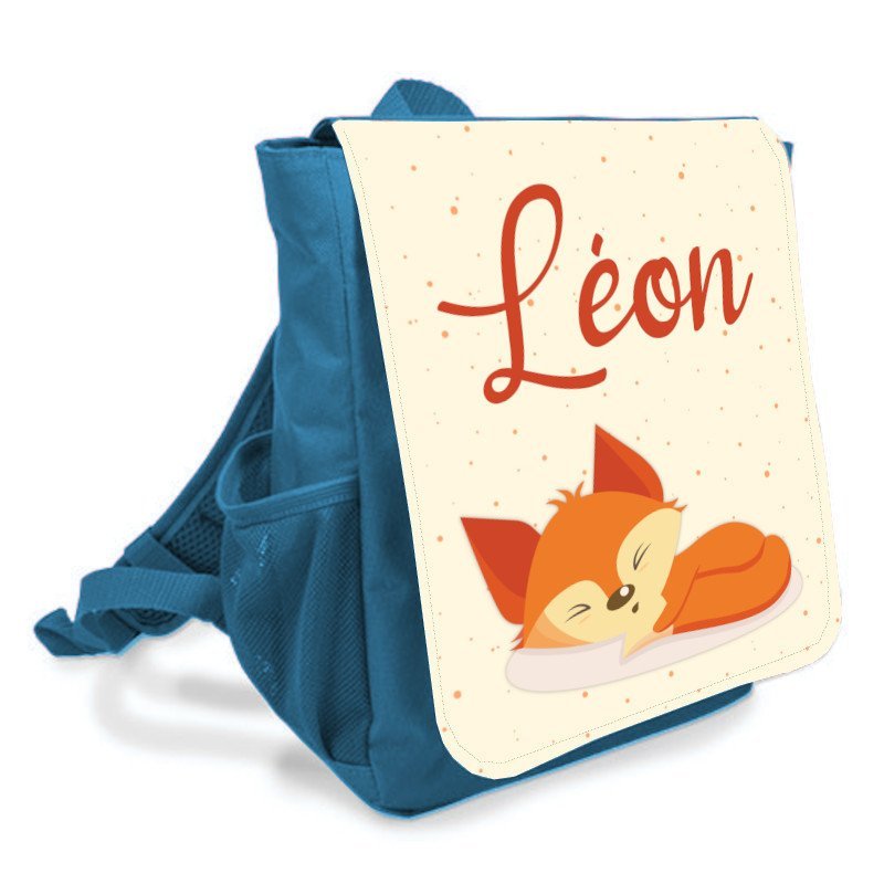 Sac à dos bleu avec rabat illustré d’un petit renard endormi et prénom « Léon », prêt pour la rentrée des classes maternelle.