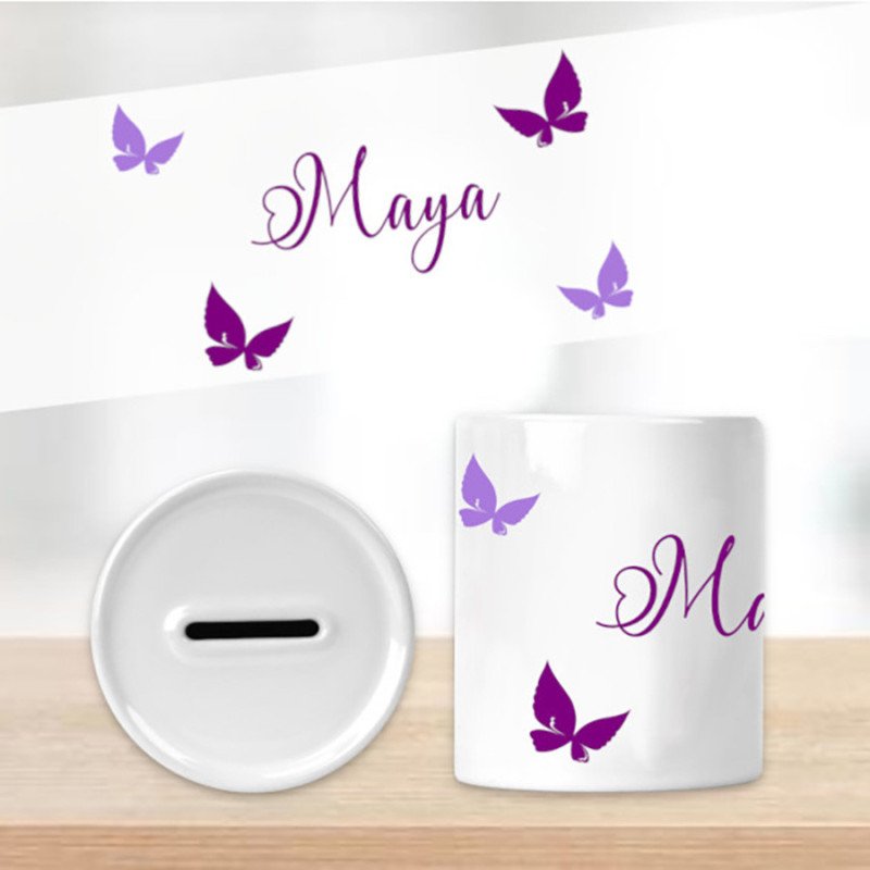 Tirelire baptême personnalisé avec prénom, mug blanc orné de papillons violets et prénom gravé en élégante écriture.